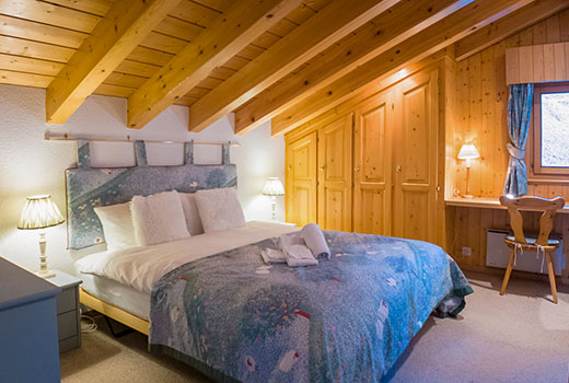 Master king bedroom with en-suite and desk area at private chalet for hire in Verbier